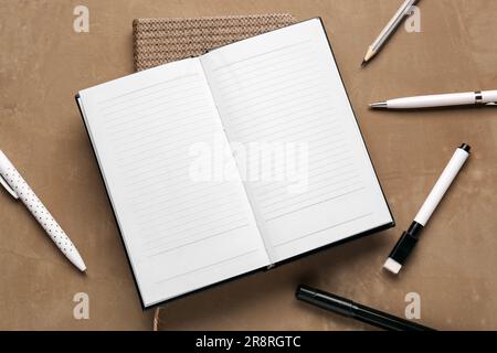 Notebooks with different school stationery on grunge brown background Stock Photo