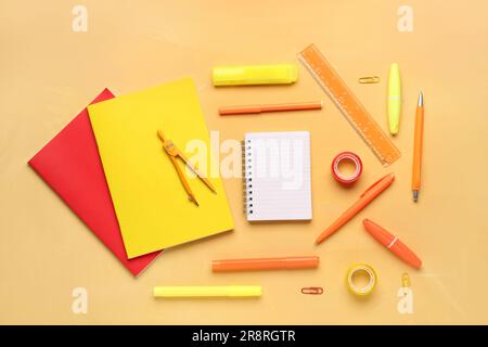 Notebooks with different school stationery on orange background Stock Photo