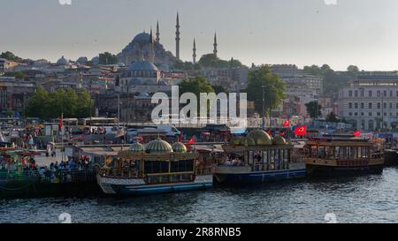 Balik Ekmek (fish sandwich) boats at Eminonu beside the Golden Horn river in Istanbul, Turkey. Suleymaniye Mosque on the hill behind Stock Photo