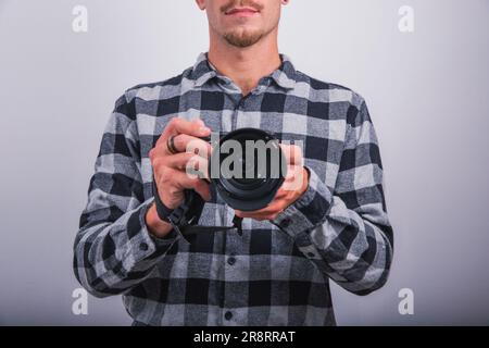 A photographer is holding a reflex camera, studio photo, half face of the person unrecognizable Stock Photo
