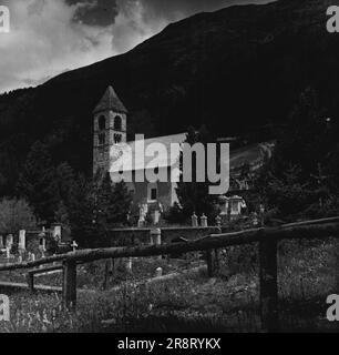 Pontresina -- Life in the High Alps of Switzerland. The Village Graveyard rises terrace-fashion against Alp Languard. The ancient church is called Church of Santa Maria; it dates back to about 1200. - Among the graves are about a dozen where English mountaineers are buried. January 22, 1948. (Photo by Pictorial Press Photo). Stock Photo