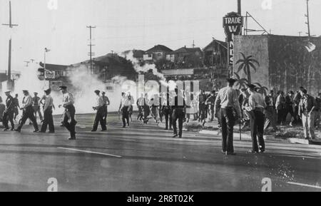 Crowd Runs As Tear Gas Let Loose -- A crowd of strikers and spectators breaksup as a tear gas bomb is let loose by police at the Standard Oil Co. refinery here today. AFL maintenance workers went through a picket line of C10 refinery workers setting off a two-hour fight between strikers and police. September 14, 1948. (Photo by AP Wirephoto) Stock Photo