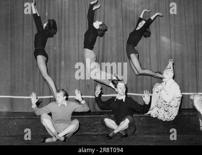 'Dodo the Clown (played by John Edmund) perches on the stage, open-mouthed with astonishment, as ballet girls, from left, Kay Smith, Pauline Menzies and Vivien Arnold leap high behind Stan Page (left) and Barry Gordon during a rehearsal of 'Dodo and the Bunyip', and Australian Fantasy for children. It will open at the Arrow Theatre, Middle Park, on Saturday night for a seven-day season. 'Dodo' became a favorite when he appeared before 20,000 Victorian school children in a series of concerts in the last two months. September 30, 1954. Stock Photo