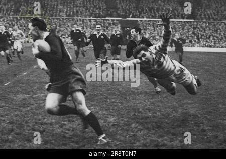 Oxford University footballer P. Johnstone flies through the air in a desperate but unsuccessful attempt to top H. Griffiths (Cambridge) in the university match at Twickenham. The match was drawn - 6-all. December 16, 1953. (Photo by Sport & General Press Agency, Limited). Stock Photo