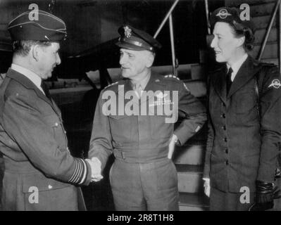 Sir Arthur Tedder Arrives -- Sir Arthur Tedder, (left), of Royal Air Force, is greeted at the National Air port today Gen. Carl A. Spaatz (centre), commander of the Pacific Strategic Air forces, as Lady Tedder (right), Looks on. The Tedders flew the Atlantic for an extended visit here. November 27, 1945. (Photo by AP Wirephoto). Stock Photo