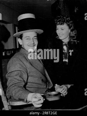 Preston Sturges. Where Did You Get That Hat? - That's what Barbara Stanwyck apparently is asking Director Preston Sturges on the set where he is directing her and Henry Fonda in 'The Lady Eve.' Strange hats are not unusual for Sturges because the Paramount director-writer has a fad for queer headwear. He says his unusual hats make it easy for others to find the director when they have questions to ask. This hat was made for him by the wardrobe man, who fashioned it out of two hats. Sturges doesn't seem to mind the appearance it gives. November 18, 1941. (Photo by Paramount Photo). Stock Photo