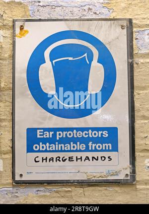 Wear hearing protection and obtain it from your chargehand, sign at Leigh Spinners Mill, Park Ln, Leigh, Wigan, Lancashire, England, UK,  WN7 2LB Stock Photo