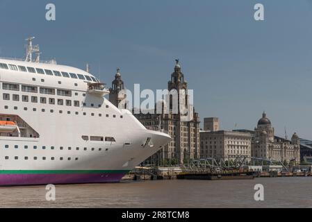 Liverpool England UK. 2023.  Cruise ship alongside in the Port of Liverpool ajoining some  historic buildings including the Liver building on the wate Stock Photo