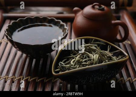 Aromatic Baihao Yinzhen tea and teapot on wooden tray, closeup. Traditional ceremony Stock Photo