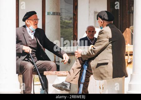 two elderly men have a conversation in a park in Pristina, Kosovo Stock Photo