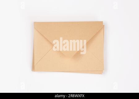 Stack of light brown paper open envelope on white isolated background. Three craft envelopes for invitations, certificates or cash gifts. Mockup, temp Stock Photo
