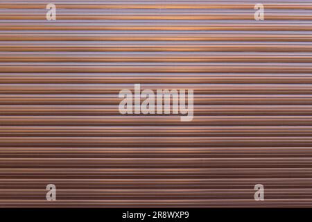 Brown roller shutter door or curtain. Grunge brown metal foldable door background and texture. Stock Photo