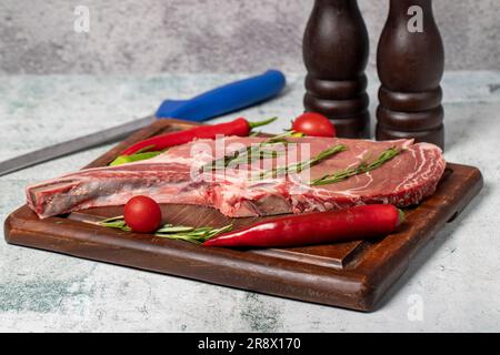 Raw veal chops. Fresh veal rib boned raw chops on wood serving board Stock Photo