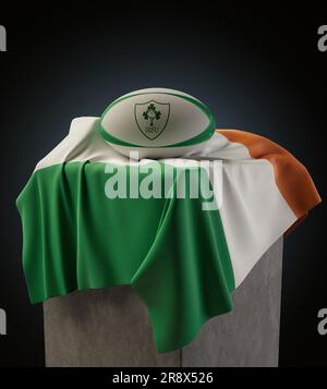 A 3D render of a generic rugby ball imprinted with the Ireland Rugby logo resting on a draped Irish flag - March 29, 2019 in Bristol, United Kingdom Stock Photo