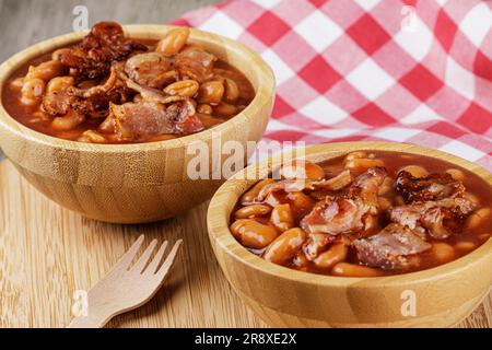 A wooden bowl of Baked Beans also known as Pork & Beans on a wooden background with copy space Stock Photo