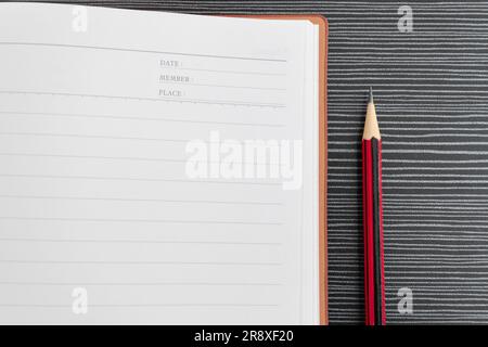 A pencil and book placed on textured table. After some edits. Stock Photo