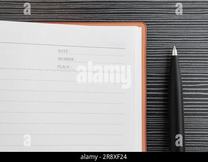 A pen and book placed on textured table, after some edits. Stock Photo