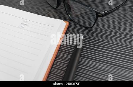 A pen, book and sunglasses placed on a textured table, after some edits. Stock Photo