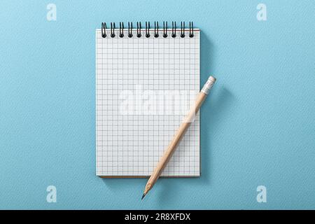 Notepad And Wooden Pencil On Blue Background Stock Photo