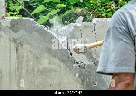 Hand of worker using hammer smashing and demolish on brick block wall at construction site Stock Photo