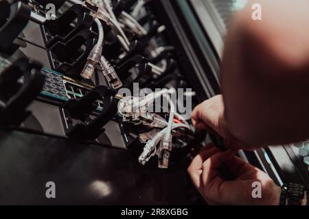 Close up of technician setting up network in server room  Stock Photo