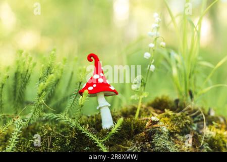 Fabulous plasticine fly agaric in the forest. Green blurred natural background. Stock Photo