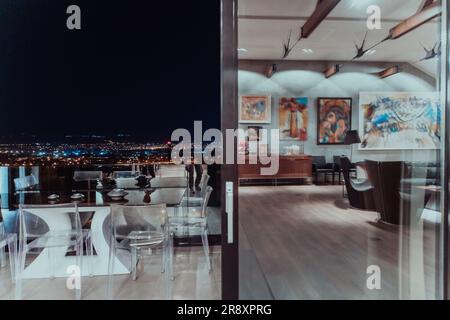 A beautiful house with a beautiful view of the night city. Luxury living room and tereasa with a view of the city. Night photo of a luxury house Stock Photo