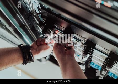 Close up of technician setting up network in server room  Stock Photo