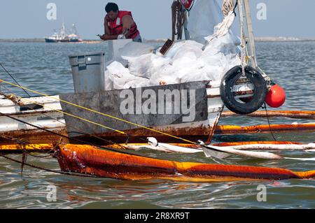 Commercial fishing boats have been converted to oil cleanup crews as part of the 'vessels of opportunity' program managed by BP. Stock Photo