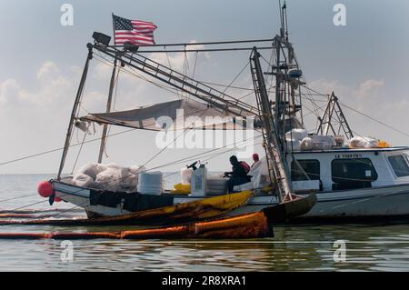 Commercial fishing boats have been converted to oil cleanup crews as part of the 'vessels of opportunity' program managed by BP. Stock Photo