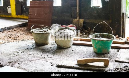 A male construction worker installs a large ceramic tile Stock Photo