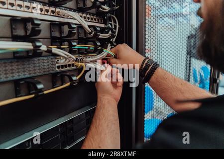 Close up of technician setting up network in server room  Stock Photo