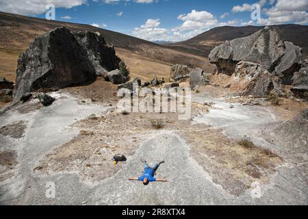 A man lying down between some rocks in Hatun Machay, Peru. Stock Photo