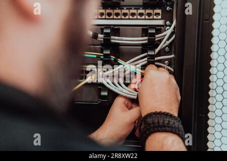 Close up of technician setting up network in server room  Stock Photo