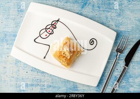 Turkish baklava with hazelnuts on a white porcelain plate Stock Photo