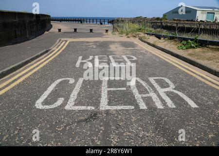 Keep clear painted road markings at a coastal jetty entrance Stock Photo