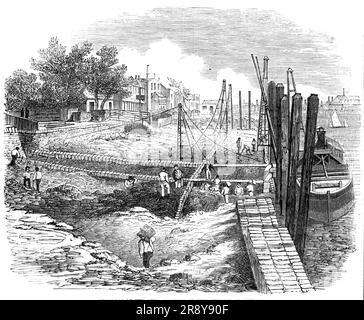 Progress of the Embankment of the Thames at Chelsea, [London], 1857. View of '...a portion in progress by Mr. Jay, the contractor, under the Woods and Works, extending nearly from [Vauxhall-bridge] to the entrance to the Grosvenor Canal, Chelsea...The entrances to the different docks, canals, &amp;c., are spanned by straight cast-iron girders, and the roadway made good over, so as to avoid any obstruction to the public, and will thus afford an uninterrupted promenade for the whole distance; the foundation, as shown in the Drawing, is done by what is called half-tide work; and the barge alongsi Stock Photo