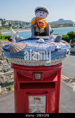 A knitted and crocheted postbox topper celebrating the RNLI, Criccieth, Gwynedd, North Wales Stock Photo