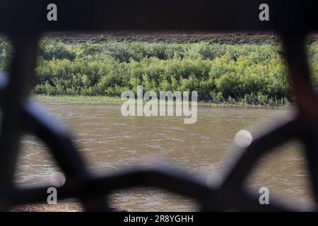 June 21, 2023, Jolfa, East Azerbaijan, Iran: A view of the Aras River at the border between northwestern Iran and Azerbaijan. The Aras (the Araks, Arax, Araxes, or Araz) is a river in the Caucasus. It rises in eastern Turkey and flows along the borders between Turkey and Armenia, between Turkey and the Nakhchivan exclave of Azerbaijan, between Iran and both Azerbaijan and Armenia, and, finally, through Azerbaijan where it flows into the Kura River. It drains the south side of the Lesser Caucasus Mountains while the Kura drains the north side of the Lesser Caucasus. The river's total length is Stock Photo