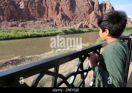 June 21, 2023, Jolfa, East Azerbaijan, Iran: A boy looks at the Aras River at the border between northwestern Iran and Azerbaijan. The Aras (the Araks, Arax, Araxes, or Araz) is a river in the Caucasus. It rises in eastern Turkey and flows along the borders between Turkey and Armenia, between Turkey and the Nakhchivan exclave of Azerbaijan, between Iran and both Azerbaijan and Armenia, and, finally, through Azerbaijan where it flows into the Kura River. It drains the south side of the Lesser Caucasus Mountains while the Kura drains the north side of the Lesser Caucasus. The river's total lengt Stock Photo