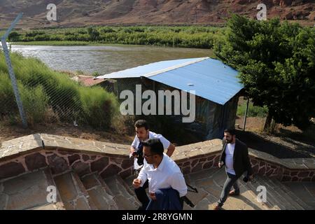 June 21, 2023, Jolfa, East Azerbaijan, Iran: Three men walk near the Aras River at the border between northwestern Iran and Azerbaijan. The Aras (the Araks, Arax, Araxes, or Araz) is a river in the Caucasus. It rises in eastern Turkey and flows along the borders between Turkey and Armenia, between Turkey and the Nakhchivan exclave of Azerbaijan, between Iran and both Azerbaijan and Armenia, and, finally, through Azerbaijan where it flows into the Kura River. It drains the south side of the Lesser Caucasus Mountains while the Kura drains the north side of the Lesser Caucasus. The river's total Stock Photo
