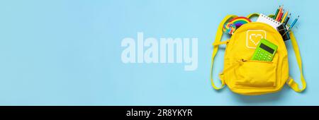 Back to school, education concept Yellow backpack with school supplies - notebook, pens, eraser rainbow, numbers isolated on blue background Top view Stock Photo