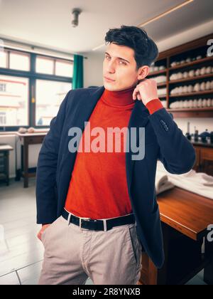 Handsome young man wearing suit in tailor shop Stock Photo
