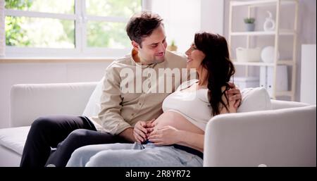 Close-up Photo Of Pregnant Couple Touching Belly Stock Photo