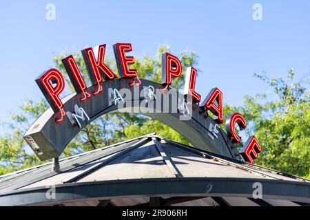 Seattle, WA, USA-July 2022; Low angle close up view of neon sign with red letter of Pike Place Market on top of the bus stop shelter Stock Photo