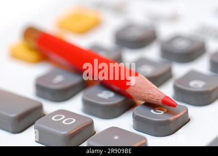 Red crayon on computer keyboard, red pencil Stock Photo