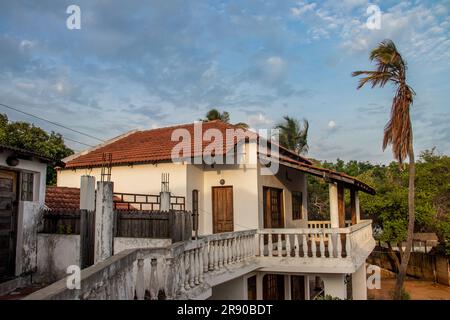 Old white house with big balcony connecting two buildings, at the beach of Indian Ocean, constructed in colonial Portuguese style Stock Photo