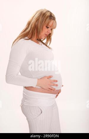 Pregnant woman holding her stomach Stock Photo