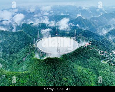 Pingtang. 22nd June, 2023. This aerial photo taken on June 22, 2023 shows China's Five-hundred-meter Aperture Spherical Radio Telescope (FAST) under maintenance in southwest China's Guizhou Province. China's FAST telescope identified a binary pulsar with an orbital period of 53.3 minutes, the shortest known period for a pulsar binary system. The research, mainly conducted by a team led by scientists from the National Astronomical Observatories of the Chinese Academy of Sciences (NAOC), was published in the journal Nature Wednesday. Credit: Ou Dongqu/Xinhua/Alamy Live News Stock Photo