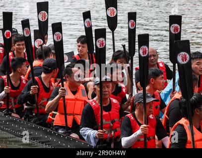 (230623) -- GUANGZHOU, June 23, 2023 (Xinhua) -- Oarsmen of a visiting dragon boat raise their oars at Pantangwuyue historical community in Guangzhou, south China's Guangdong Province, on June 22, 2023. For many years during the Dragon Boat Festival, people of several villages in the Lingnan area follow a tradition to row dragon boats to visit their 'dragon boat's relative'. The 591-year-old Yanbu dragon boat has been enjoying a popularity in the border area of Guangzhou and Foshan, where dragon boat race has a long history, from as early as 1597. On that year, people rowing Yanbu dragon boa Stock Photo